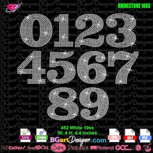 May include: Ten white rhinestone numbers, 0 through 9, in a white background. Each number is approximately 4 inches wide and 4.4 inches high. The numbers are arranged in two rows, with the numbers 0, 1, 2, and 3 in the top row and the numbers 4, 5, 6, 7, 8, and 9 in the bottom row. The numbers are made of small, white rhinestones that are set in a clear adhesive. The numbers are perfect for creating custom designs on clothing, bags, shoes, and other accessories.