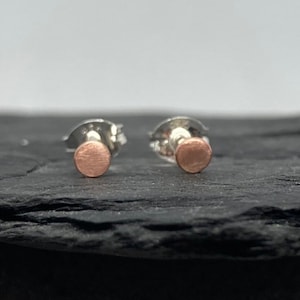 Tiny round copper stud earrings with a satin finish