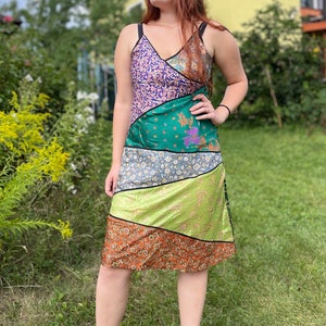 Pode incluir: Um vestido sem mangas com um design de patchwork que apresenta uma variedade de cores e padrões, incluindo verde, roxo, laranja e amarelo. O vestido tem uma silhueta reta e um comprimento midi.