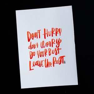 May include: A white card with red watercolor calligraphy that reads "Don't hurry, don't worry, do your best, leave the rest."