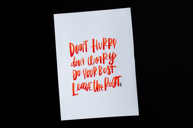 May include: A white card with red watercolor calligraphy that reads "Don't hurry, don't worry, do your best, leave the rest."