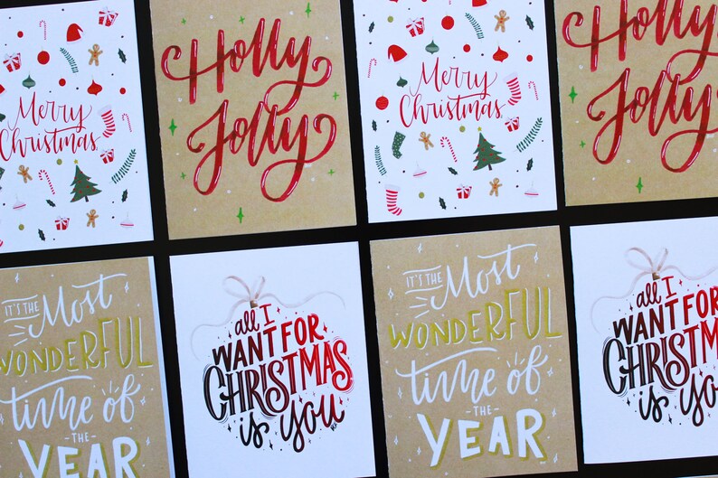 K&ouml;nnte beinhalten: Sechs verschiedene Weihnachtskarten mit handgeschriebener Kalligraphie. Die Karten zeigen S&auml;tze wie "Holly Jolly", "Es ist die sch&ouml;nste Zeit des Jahres" und "Alles, was ich mir zu Weihnachten w&uuml;nsche, bist du".
