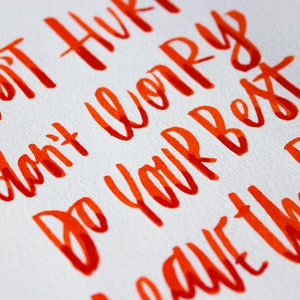 May include: Orange handwritten text on a white background that reads "Don't hurry, don't worry, do your best, have the rest."
