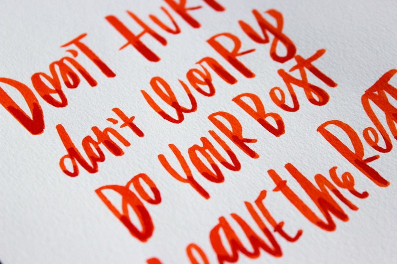 May include: Orange handwritten text on a white background that reads "Don't hurry, don't worry, do your best, have the rest."