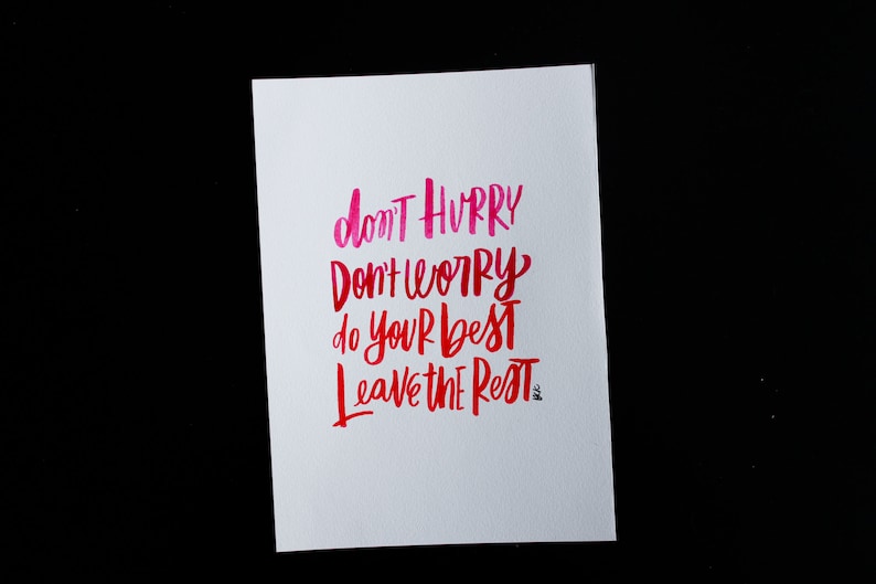 May include: A white card with pink and red handwritten text that reads "don't hurry don't worry do your best leave the rest".