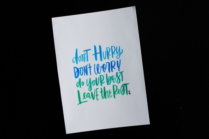 May include: A white card with blue and green lettering that reads "Don't hurry, don't worry, do your best, leave the rest".