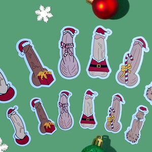 May include: A set of ten Christmas-themed stickers featuring a variety of designs. The stickers are all white with a red and white Santa hat on top. Some of the stickers have a red and white candy cane, a red and white gift box, or a red and white Santa suit. The stickers are all on a green background.