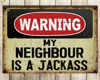 May include: A rusty metal sign with a black background and red oval warning sign that says "WARNING". The sign says "MY NEIGHBOUR IS A JACKASS" in black text on a beige background.