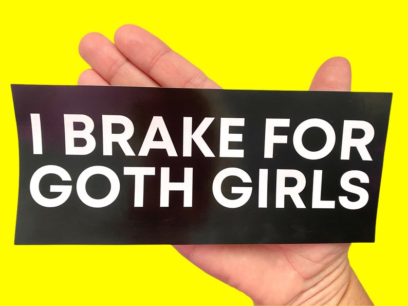 May include: Black and white bumper sticker with the text "I Brake For Goth Girls".