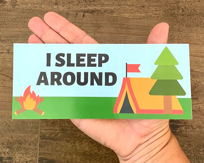 May include: A blue and green camping-themed sticker with the text "I SLEEP AROUND". The sticker features a campfire, a tent with a red flag, and a green pine tree.