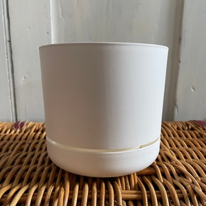 Peut inclure: Un pot de fleurs blanc avec une soucoupe assortie. Le pot a une surface texturée et un design simple et moderne. Le pot convient à une utilisation intérieure ou extérieure.