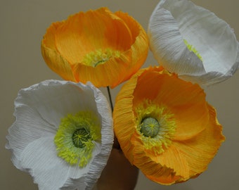 Könnte beinhalten: Vier Papierblumen, zwei weiße und zwei gelbe, mit gekräuselten Blütenblättern. Die Blumen sind zu einem Strauß angeordnet.