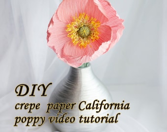 May include: DIY crepe paper California poppy video tutorial. A pink crepe paper poppy flower in a silver vase.