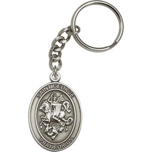 May include: Silver key chain with a round medallion featuring Saint George slaying a dragon. The medallion is inscribed with "Saint George Pray For Us".