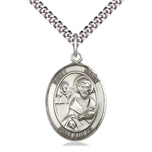 May include: Silver oval pendant necklace featuring an image of Saint Mark with the text "Saint Mark Pray For Us". The pendant hangs from a silver chain. Religious jewelry.
