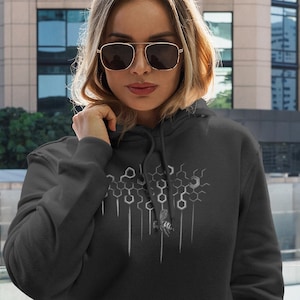 May include: A dark grey hooded sweatshirt with a white graphic design of a honeycomb pattern and a small bee. The hoodie has a kangaroo pocket and a drawstring hood.