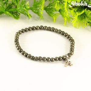 May include: A grey beaded bracelet with a silver charm that says "R" hanging from it.