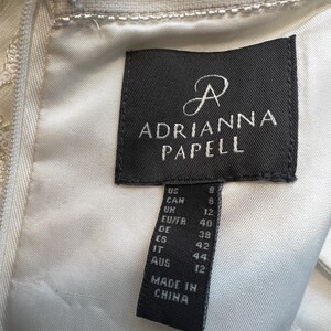 May include: A black and white size tag with the text "Adrianna Papell" and size conversions for US, Canada, UK, EU/FR, DE, ES, IT, and AUS. The tag also says "Made in China."