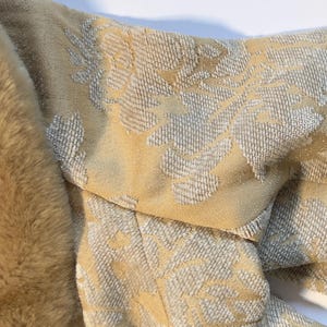 May include: Close-up of a section of a garment with a floral pattern in shades of beige and gray. The garment is next to a faux fur trim. The text "STANDARD WHITE PRINTER PAPER for COLOR COMPARISON" is in the background.