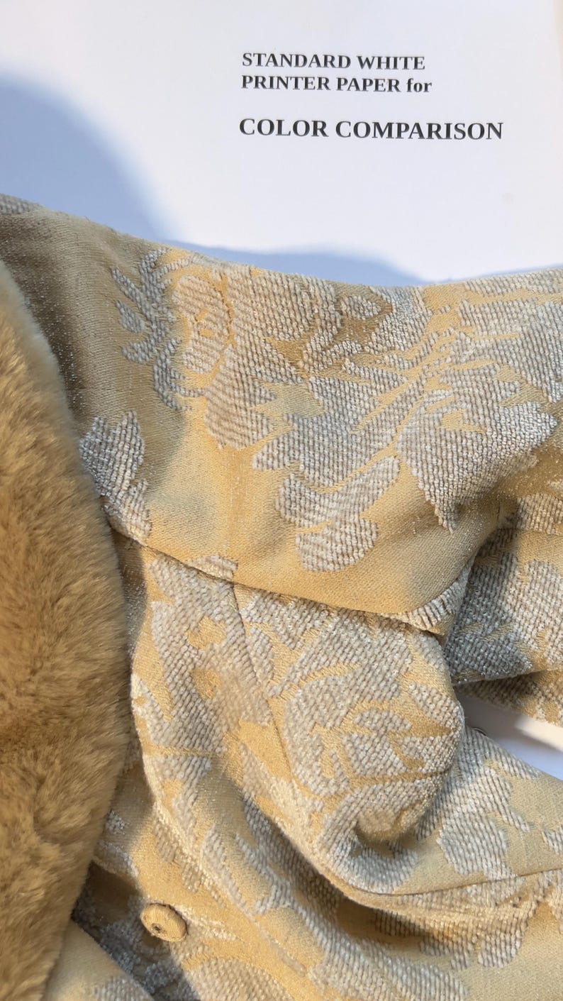 May include: Close-up of a section of a garment with a floral pattern in shades of beige and gray. The garment is next to a faux fur trim. The text "STANDARD WHITE PRINTER PAPER for COLOR COMPARISON" is in the background.
