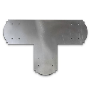 May include: A silver metal T-shaped bracket with decorative edges and multiple holes for mounting.