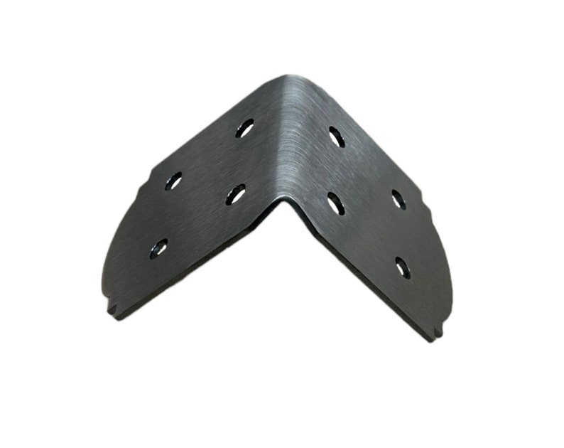 Op de afbeelding: Een zilveren metalen hoekbeugel met meerdere gaten om aan een oppervlak te bevestigen. De beugel is ontworpen om hoeken te versterken en te beschermen.