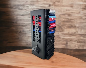 May include: Black metal beer can holder with the word "BEER ME" cut out. The holder has a bottle opener attached to the side. The holder is filled with colorful koozies.