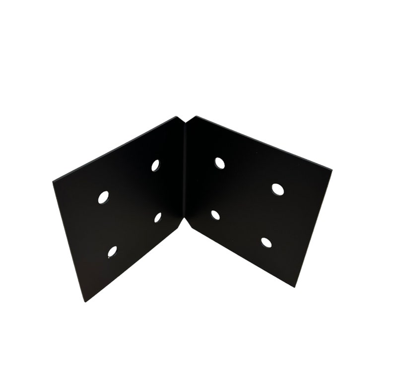 May include: A black metal corner brace with six pre-drilled holes. The brace is designed at a 90-degree angle, suitable for joining two surfaces. The finish is matte black, providing a clean, industrial aesthetic.