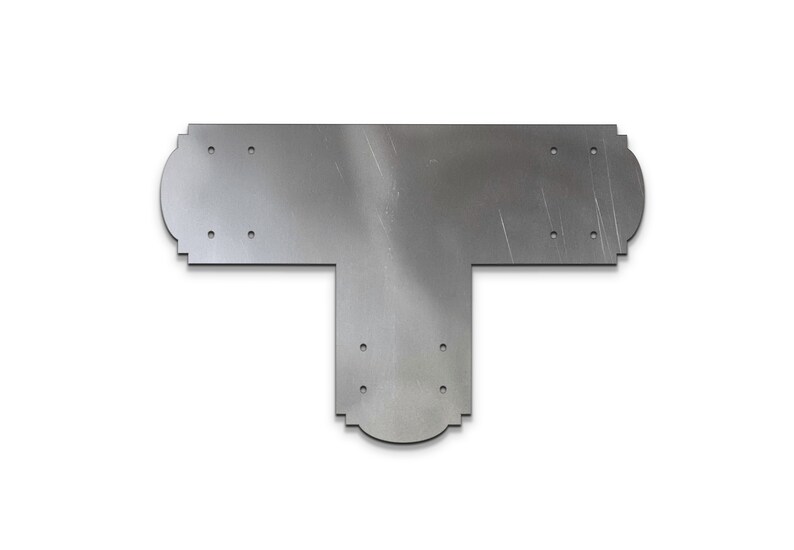 May include: A silver metal T-shaped bracket with decorative edges and multiple holes for mounting.