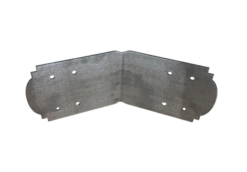 May include: A silver metal corner brace with a decorative edge and four holes for screws.