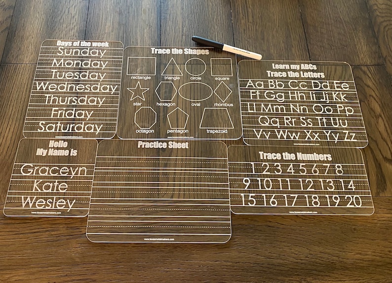 May include: Six transparent, reusable dry-erase activity mats for kids.  The mats feature various educational tracing activities: days of the week, shapes (rectangle, triangle, circle, square, star, hexagon, oval, rhombus, octagon, pentagon, trapezoid), alphabet (A-Z), and numbers (1-20).  Each mat has clear lines for tracing practice.  A white dry-erase marker is included.