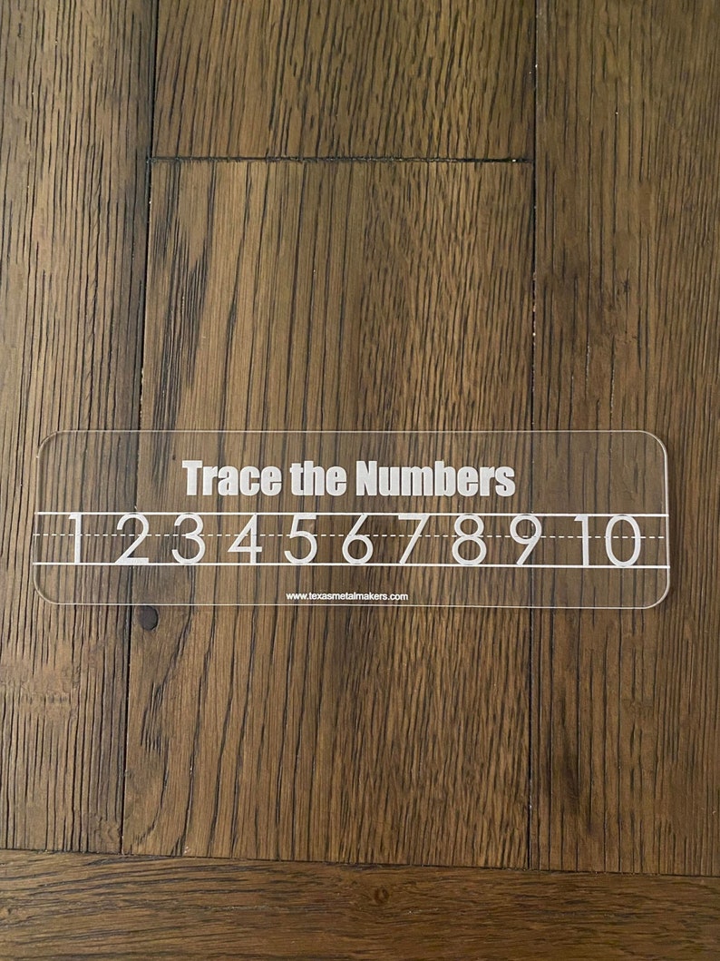 Op de afbeelding: Een transparante acryl traceergids met de tekst "Trace the Numbers" en de cijfers 1 tot en met 10. Het bevat traceerlijnen en het websiteadres www.texasmetalmakers.com.