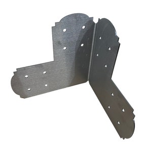 Pode incluir: Cantoneira de metal prateado com bordas decorativas e m&uacute;ltiplos furos para fixa&ccedil;&atilde;o. A cantoneira &eacute; projetada para refor&ccedil;ar e apoiar cantos em projetos de marcenaria.
