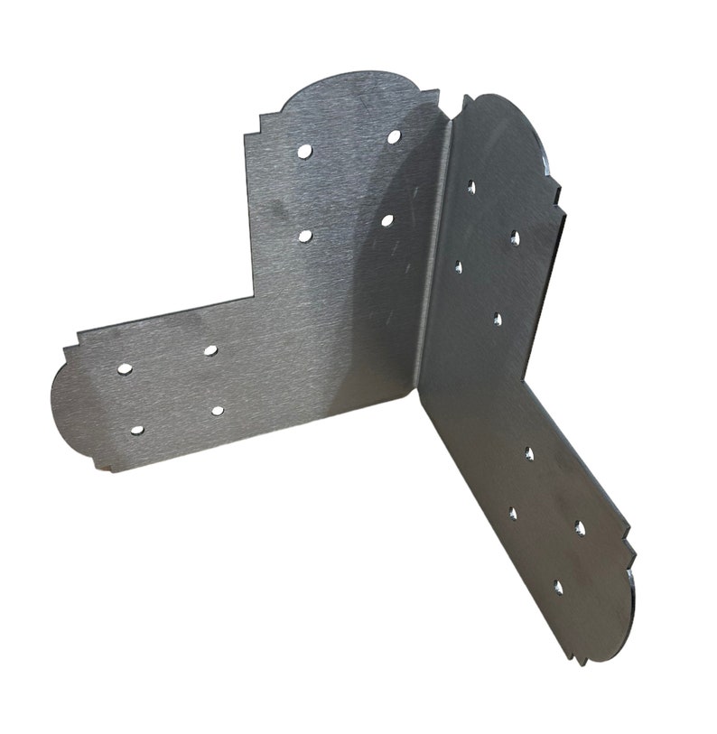 Pode incluir: Cantoneira de metal prateado com bordas decorativas e m&uacute;ltiplos furos para fixa&ccedil;&atilde;o. A cantoneira &eacute; projetada para refor&ccedil;ar e apoiar cantos em projetos de marcenaria.