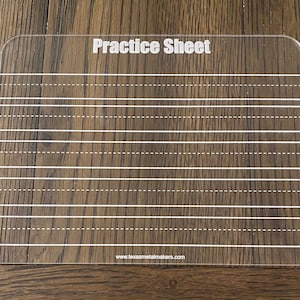 Op de afbeelding: Een heldere acryl oefenvel met witte gedrukte lijnen en de woorden "Practice Sheet" bovenaan. Het vel heeft afgeronde hoeken en is ontworpen voor het oefenen van handschrift. De website www.texasmetalmakers.com is onderaan afgedrukt.