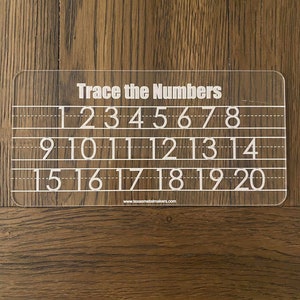 Op de afbeelding: Een doorzichtig acryl traceerbord met de tekst "Trace the Numbers" bovenaan. Het bord bevat de cijfers 1 tot en met 20 in handschriftstijl, met stippellijnen om te oefenen met traceren. De website www.texasmetalmakers.com staat onderaan.