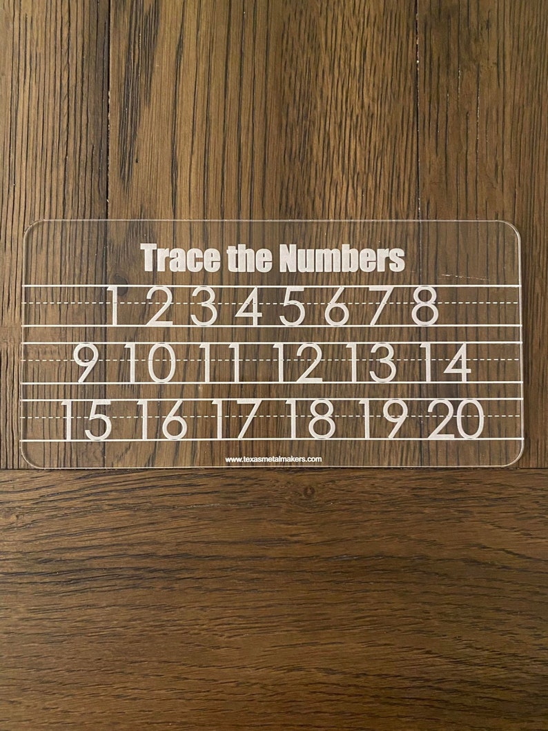 Op de afbeelding: Een doorzichtig acryl traceerbord met de tekst "Trace the Numbers" bovenaan. Het bord bevat de cijfers 1 tot en met 20 in handschriftstijl, met stippellijnen om te oefenen met traceren. De website www.texasmetalmakers.com staat onderaan.