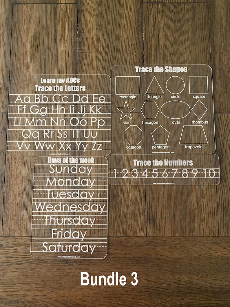 Op de afbeelding: Een set van vier transparante acryl traceerborden voor vroeg leren. Bevat borden voor het traceren van letters, vormen, cijfers en dagen van de week. Elk bord heeft witte tekst en contouren om te traceren. De set is gelabeld met "Bundle 3".