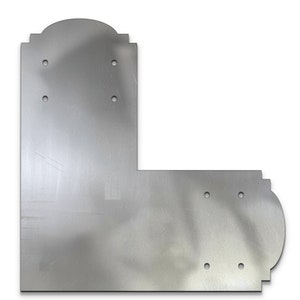 May include: A silver metal corner bracket with decorative edges and multiple holes for mounting.