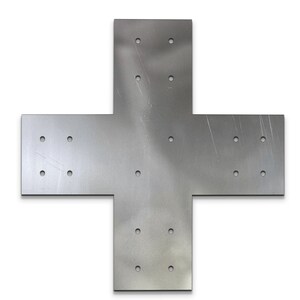 May include: A silver-colored metal cross-shaped bracket with multiple pre-drilled holes for mounting. The bracket is made of a flat, solid material and is designed for structural support. The surface has visible scratches.