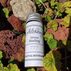 May include: A small, white bottle with a silver lid. The label reads "Alchemy Divine Healing 777 Spiritual Boundaries".