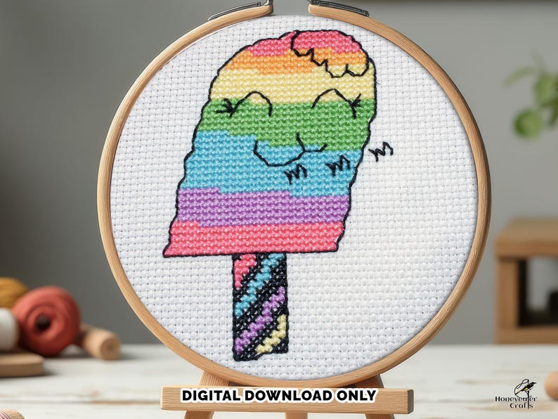 Rainbow stripe kawaii ice cream cross stitch pattern shown in a small embroidery hoop.