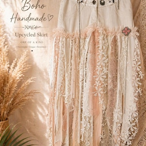 May include: A cream-coloured upcycled skirt in a boho style, with a denim base and layers of lace and fabric in cream and blush pink. It has decorative chains and a pink floral brooch. The text "Boho Handmade" is visible.
