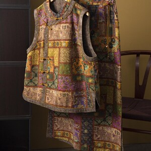 Può includere: Un completo a due pezzi composto da gilet e gonna. Il gilet ha un colletto alla coreana e chiusure a ranella. La gonna ha una vita con coulisse. Entrambi i capi presentano un design patchwork nei toni del marrone, verde, viola e giallo, con motivi di elefanti.