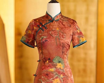 May include: A red and orange cheongsam dress with a floral print and a teal collar. The dress has a mandarin collar and a side closure with buttons.