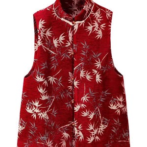 Può includere: Un gilet rosso senza maniche con colletto alla coreana e chiusura con bottoni. Il gilet presenta un motivo a foglie di bambù in bianco e grigio. Capo in stile tradizionale.