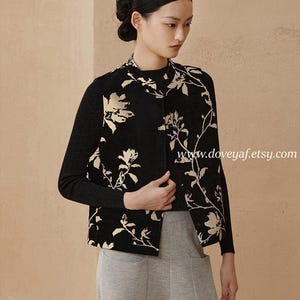 May include: A black jacket with a floral pattern in cream and a black long-sleeved top. The model is wearing gray pants. The website address www.doveyaf.etsy.com is visible in the image.
