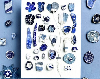 Textile wall art with 31 blue embroidered plant pieces presented