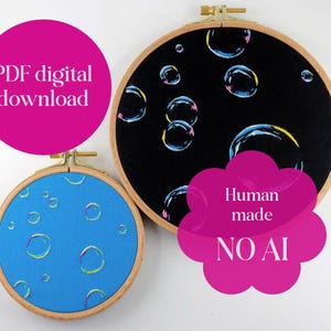 May include: Two circular wooden embroidery hoops containing fabric with bubble patterns. One hoop features a black fabric background with large bubbles, while the smaller hoop has a blue fabric background with smaller bubbles. Text reads PDF digital download and Human made NO AI.