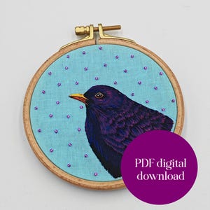 Peut inclure: Broderie artisanale d'un merle noir sur fond bleu clair, ornée de perles violettes. L'oiseau a un bec jaune et est encadré dans un cercle à broder en bois. Un cercle violet avec le texte "PDF digital download" est en bas à droite.